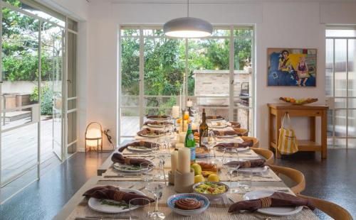 a long table with plates of food on it at Carmelo Keren Villa in Kesar Shenaryahu