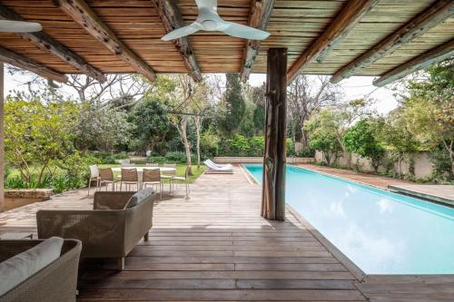 an outdoor patio with a pool and a ceiling fan at Carmelo Keren Villa in Kesar Shenaryahu