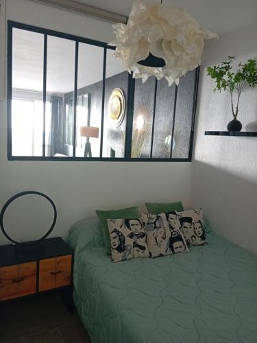 une chambre avec un lit vert et une fenêtre dans l'établissement vue meŕ, à Marseillan