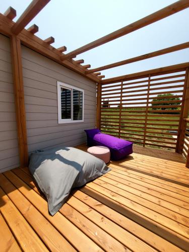 a wooden deck with a bed and a pergola at VioVillas Agriturismo Glamping Arezzo in Arezzo