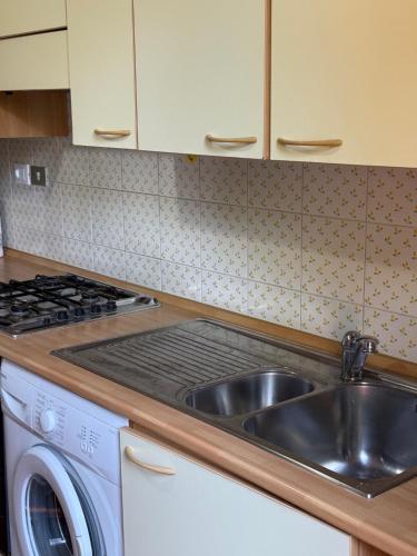 a kitchen with a sink and a washing machine at Casolare De Ranieri - appartamento in villa bifamiliare a 500m dal mare in Marina di Massa