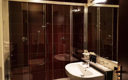 a bathroom with a shower and a sink and a mirror at JR Hotels Bologna Amadeus in Bologna