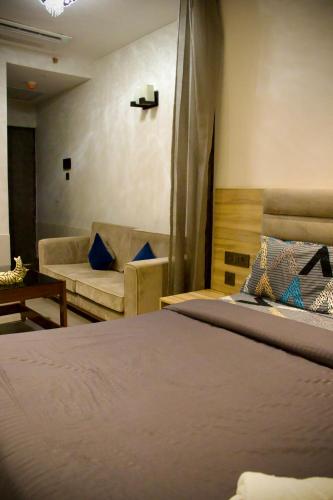 a bedroom with a bed and a couch at The Arc - Supernova in New Delhi