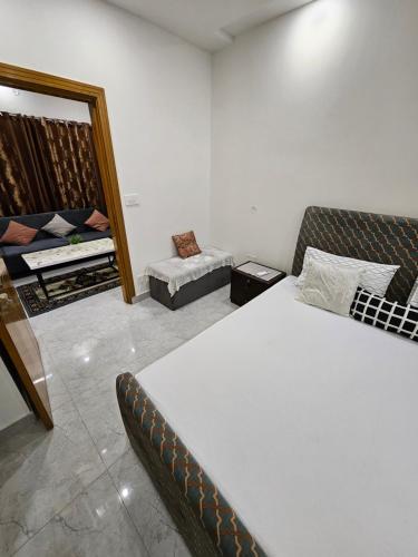 a bedroom with a bed and a couch and a mirror at StayNova - Transit Apartment near Motorways & Airport in Islamabad