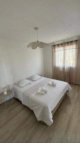 - une chambre blanche avec un grand lit et des serviettes dans l'établissement Appartement T4, à Corte