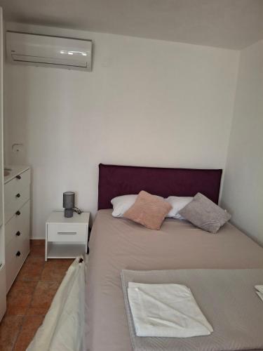 een kleine slaapkamer met een bed en een dressoir bij Anastasija in Merdari