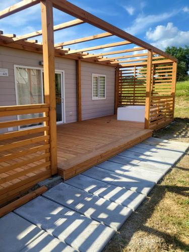 a wooden deck with a pergola on a house at VioVillas Agriturismo Glamping Arezzo in Arezzo