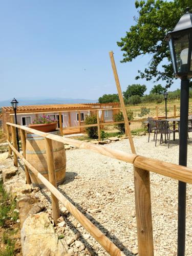 a wooden fence with a house in the background at VioVillas Agriturismo Glamping Arezzo in Arezzo