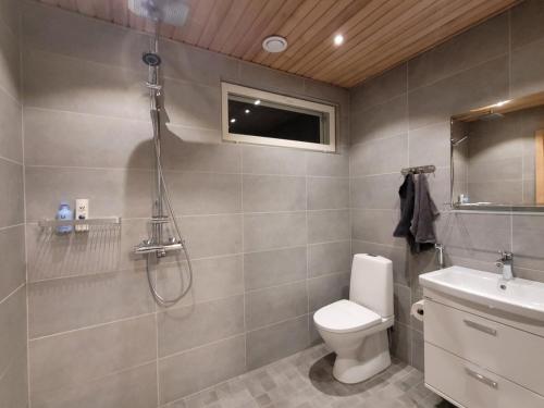 a bathroom with a shower and a toilet and a sink at The Copper Nest by Hilla Villas in Saariselka
