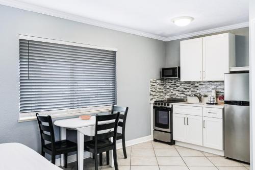 a kitchen with a table and chairs and a refrigerator at Tropical Beach Resorts - Sarasota in Sarasota