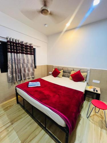 a bedroom with a large bed with red pillows at The Nomy in Calangute