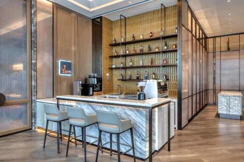 a bar in a restaurant with stools around it at Crowne Plaza Rugao in Nantong