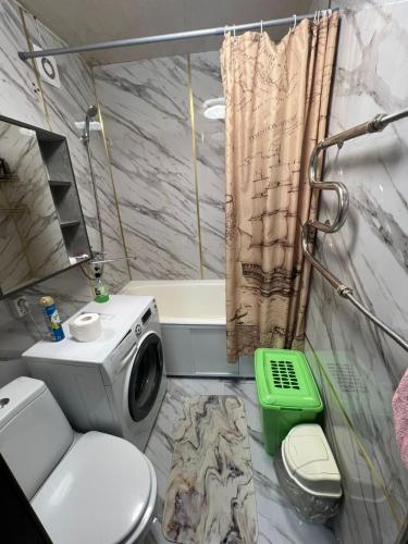 a bathroom with a shower and a washing machine at Квартира на Протозанова 39 in Ustʼ-Kamenogorsk