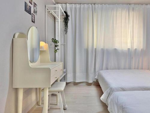 a white bedroom with a desk and a bed at Yul Stay in Seoul