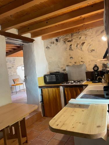 une cuisine avec une cuisinière et un comptoir dans l'établissement Charmante petite maison, à Aouste-sur-Sye