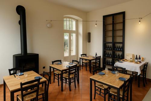a restaurant with tables and chairs and a fireplace at Locanda Del Barbaresco in Alba