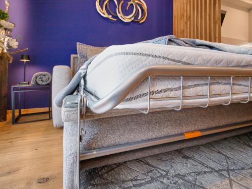 a bed frame in a bedroom with purple walls at DESIGN LODGE - Apartment with Terrace in Tyrol, presendet by AlpenLuxus in Kramsach
