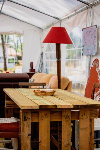 une table en bois avec une lampe rouge au-dessus dans l'établissement Le Spot La Tranche sur mer, à La Tranche-sur-Mer