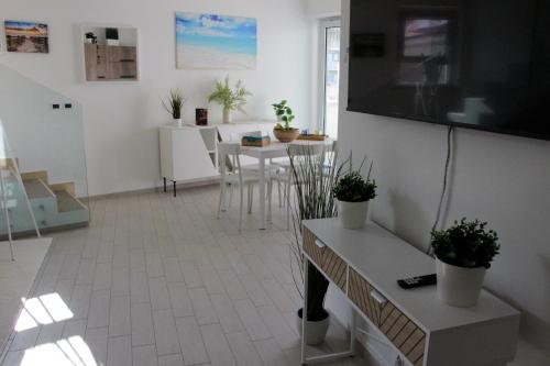 a living room with a table and a flat screen tv at Magnolia in Francavilla al Mare