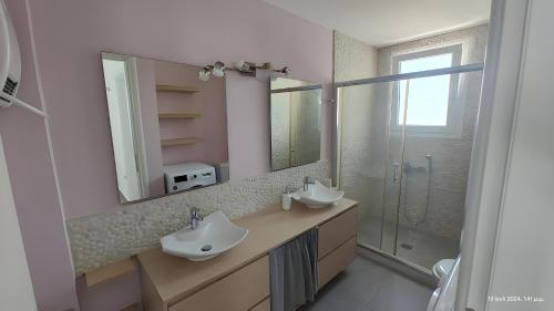 a bathroom with two sinks and a shower at Seafront Villa Christina in Kanatádhika