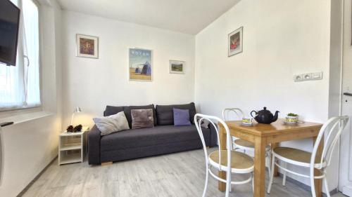 un salon avec un canapé et une table dans l'établissement Royan - APPARTEMENT - rez-de-jardin - MARCHE à DEUX PAS PLAGE à 600m, à Royan