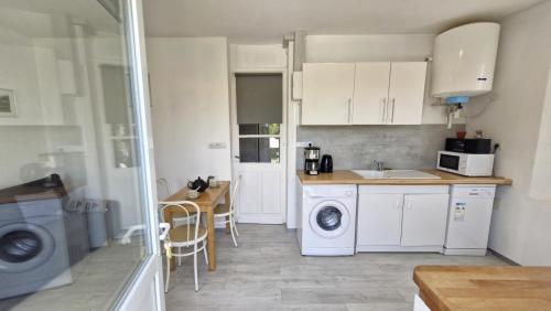 une cuisine avec une machine à laver et un évier dans l'établissement Royan - APPARTEMENT - rez-de-jardin - MARCHE à DEUX PAS PLAGE à 600m, à Royan