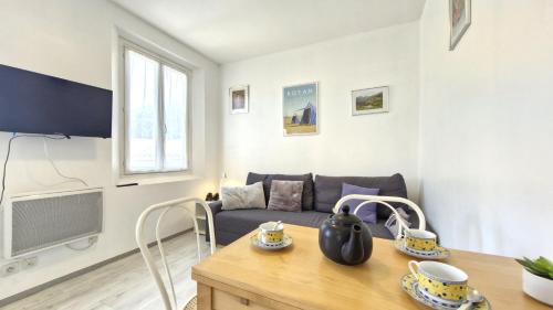 un salon avec un canapé et une table dans l'établissement Royan - APPARTEMENT - rez-de-jardin - MARCHE à DEUX PAS PLAGE à 600m, à Royan