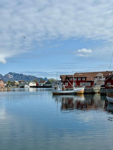 a body of water with houses and a boat at Modern apartment with balcony in the center of Svolvær in Svolvær