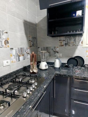 a kitchen with a stove and a counter top at Luxury Apartment Near Mall of Arabia in 6th October Family only شقة فاخرة للايجار بجوار مول العرب فقط للعائلات in 6th Of October