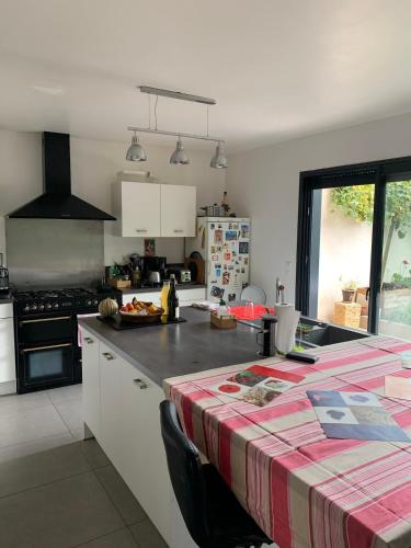 une cuisine avec une table avec une nappe rouge et blanche dans l'établissement House with hammam between city and circuit, au Mans