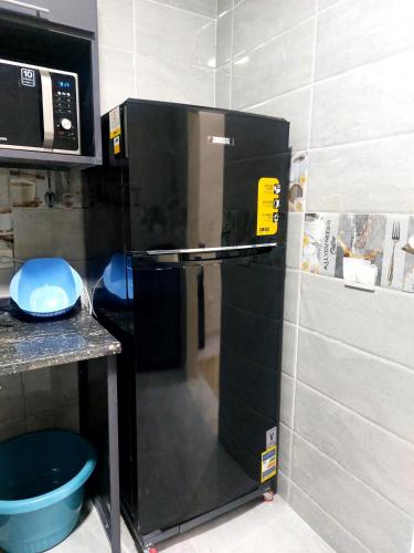 a small kitchen with a microwave and a refrigerator at Luxury Apartment Near Mall of Arabia in 6th October Family only شقة فاخرة للايجار بجوار مول العرب فقط للعائلات in 6th Of October