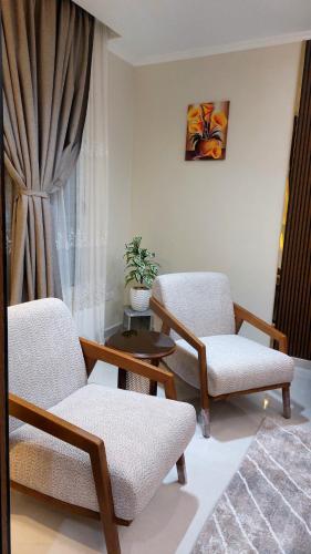 a living room with two chairs and a table at Luxury Apartment Near Mall of Arabia in 6th October Family only شقة فاخرة للايجار بجوار مول العرب فقط للعائلات in 6th Of October
