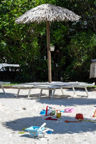 a picnic table with a straw umbrella on the beach at Villa Carlotta Jesolo Lido in Lido di Jesolo