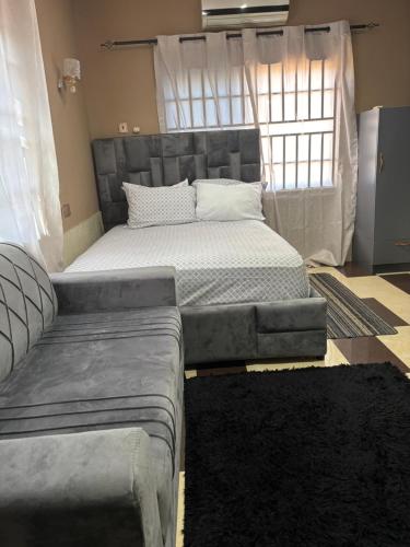 a large bed in a room with a couch at Cityscape Apartment in Trofwi