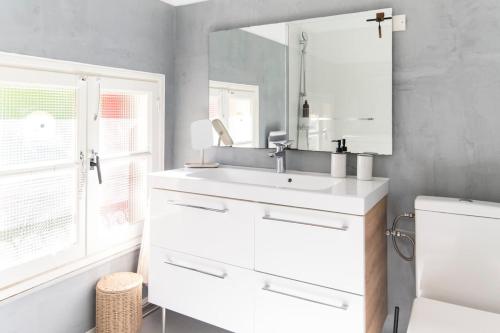 une salle de bain avec un lavabo blanc et un miroir dans l'établissement 2 bedroom house in Moulleau Beach on foot, à La Teste-de-Buch