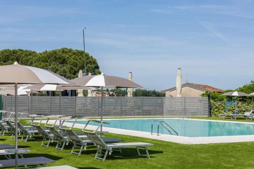 a swimming pool with lawn chairs and umbrellas next to a pool at Hotel Ristorante Al Fiore in Peschiera del Garda