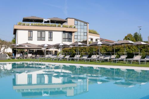 a hotel with a swimming pool with chairs and umbrellas at Hotel Ristorante Al Fiore in Peschiera del Garda