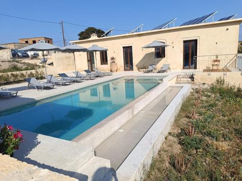 a swimming pool in front of a house at Evans Villas in Gramvousá