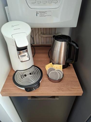 une cafetière sur une étagère en bois avec un mixeur dans l'établissement Le colibri, à Houlgate