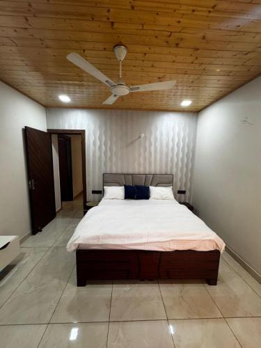 a bedroom with a bed with a ceiling fan at The Ivyview Villa Kumarhatti Barog Near Kasauli in Barog