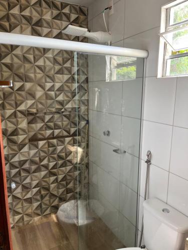 a bathroom with a glass shower with a toilet at Chácara Recanto Ribeiro in Pirenópolis