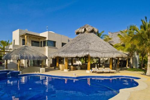 a resort with a swimming pool with chairs and umbrellas at Rancho De Costa by Cabo Villas in La Paz