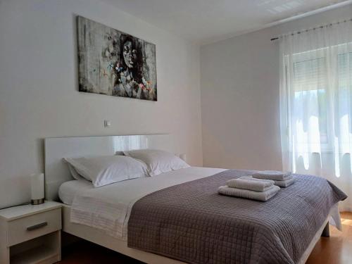 a bedroom with a bed with two towels on it at Apartments Sandra in Turanj