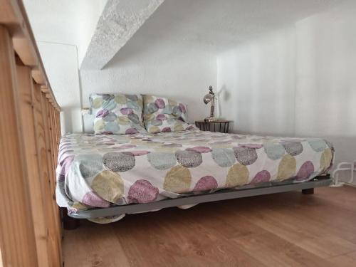 - un lit avec une couette et des oreillers dans une chambre dans l'établissement Charmant studio centre historique Aix, à Aix-en-Provence