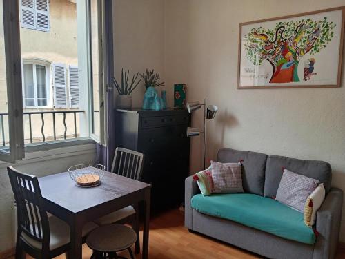 un salon avec un canapé et une table dans l'établissement Charmant studio centre historique Aix, à Aix-en-Provence