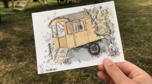a person holding up a drawing of a bus at la roulotte dépote in Monbéqui