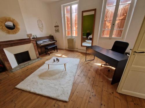 a living room with a piano and a coffee table at la roulotte dépote in Monbéqui