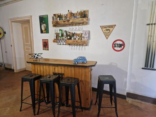 a bar with four stools in front of a counter at la roulotte dépote in Monbéqui