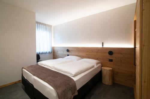 a bedroom with a bed with a wooden headboard at Casa Montana in Commezzadura