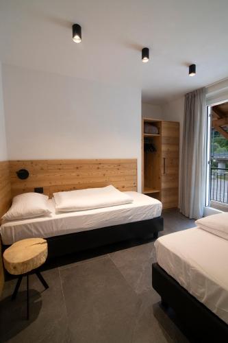 a bedroom with two beds and a window at Casa Montana in Commezzadura